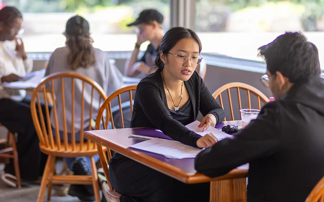 Two student LLC participants sit at a table studying in the Gizmo.