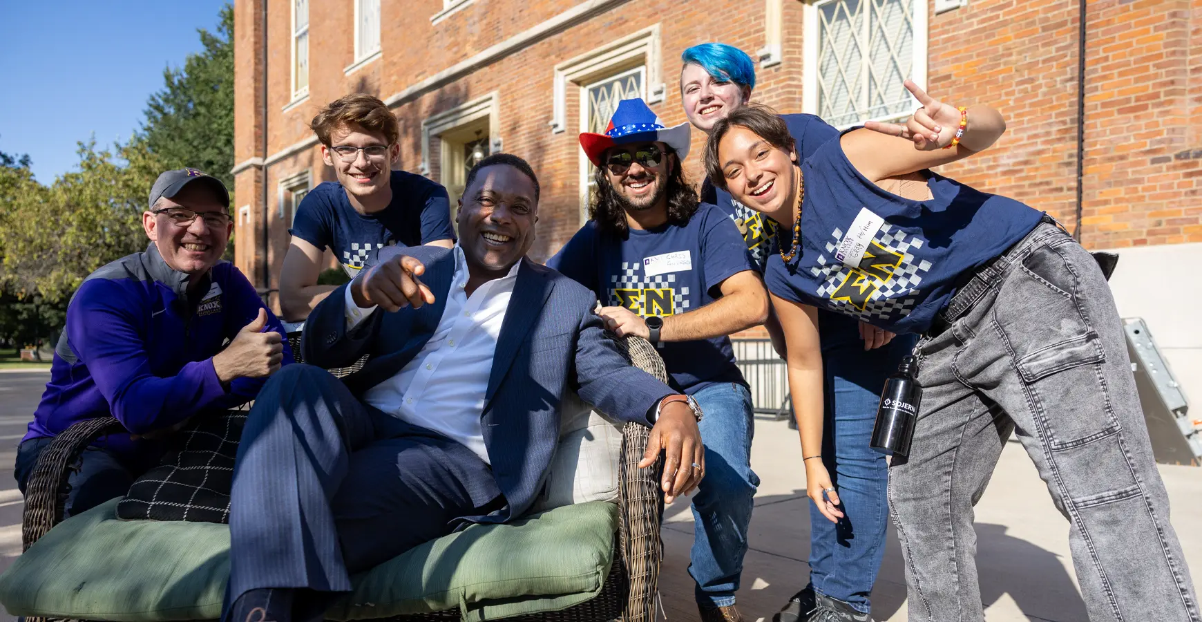A group of Knox students pose with President C. Andrew McGadney in front of Old Main.