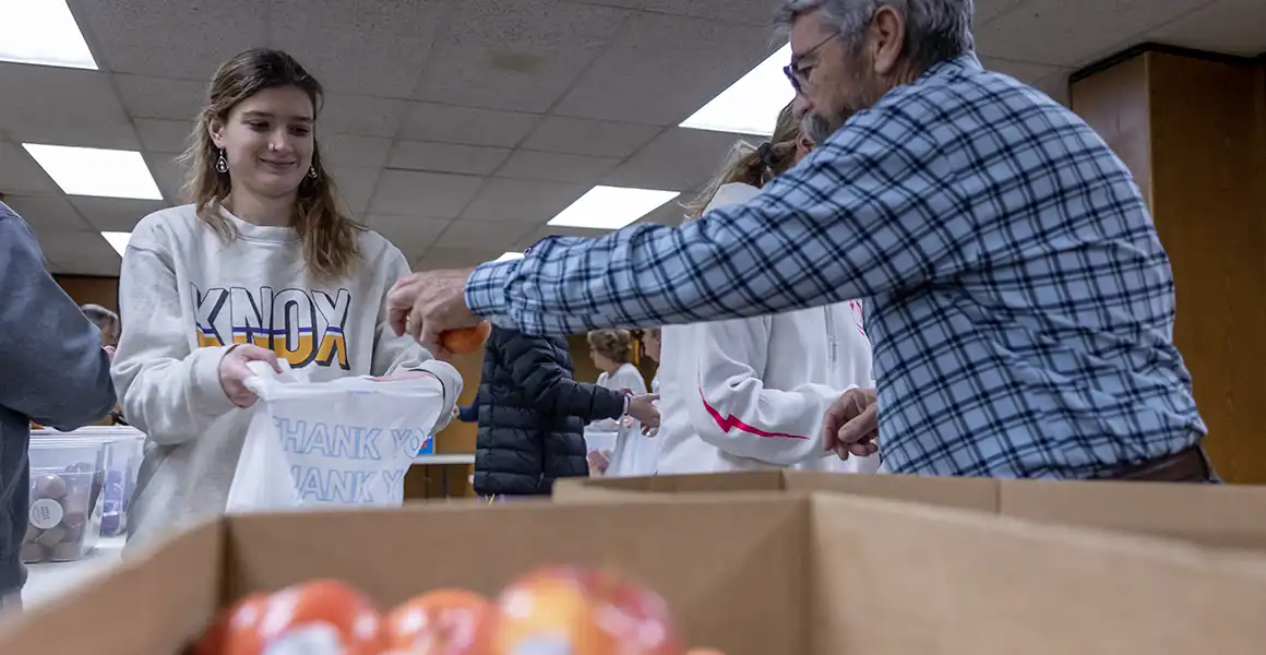 A student helping pack bags at Blessings in a Backpack.