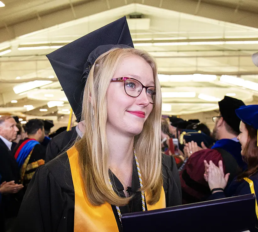 Emily smiling off the camera where her cap and gown.