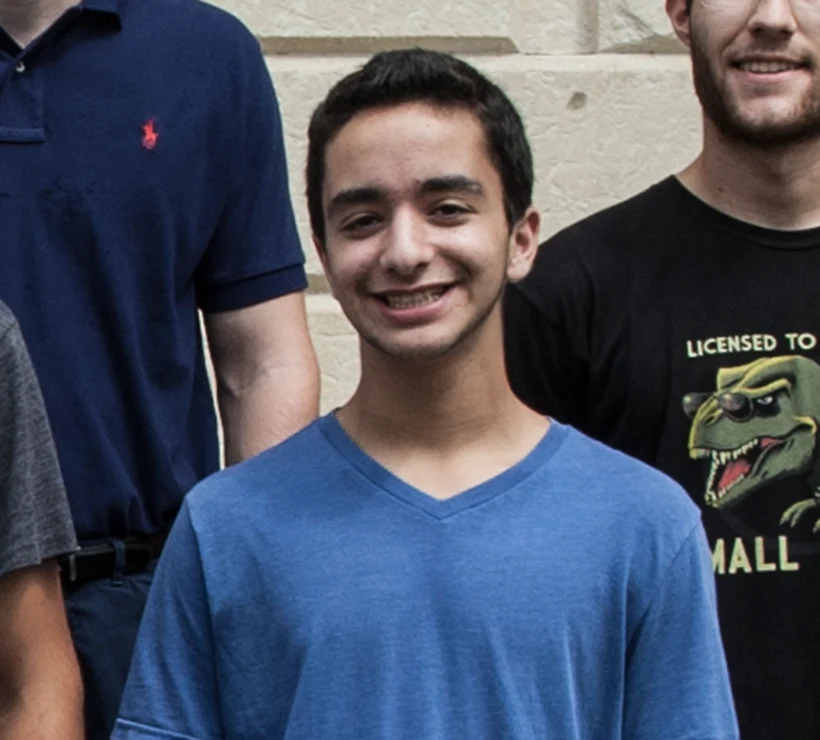 Jonathan standing in front of a building with other students smiling at the camera.