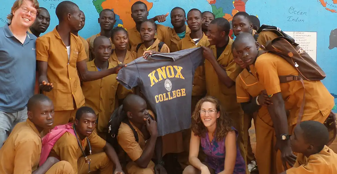 A Knox student with a school in Africa holding a Knox t-shirt