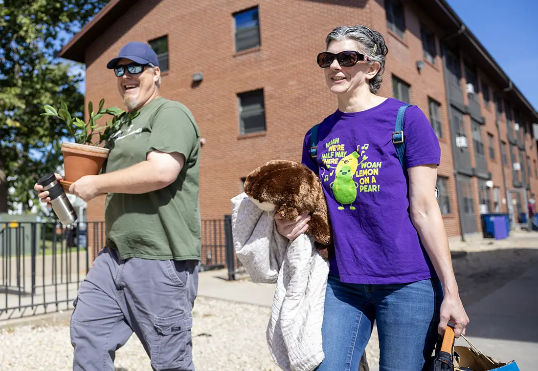 Two Knox parents carry room supplies on new student move-in.