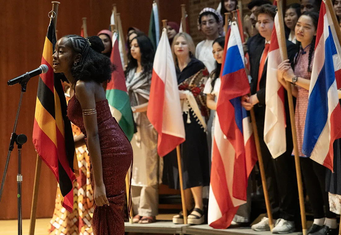 International students holding their country's flags gather on a stage at the Knox College International Fair.