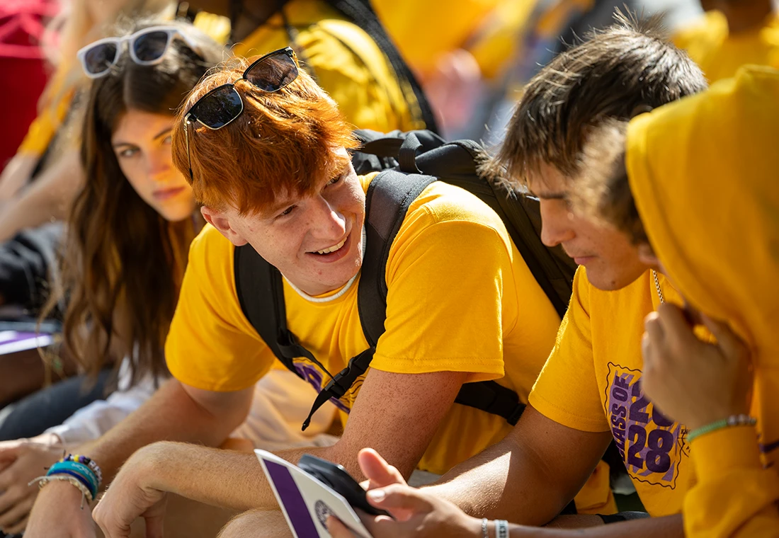 New Knox students, all in yellow t-shirts, talk as they wait for an orientation event to begin.