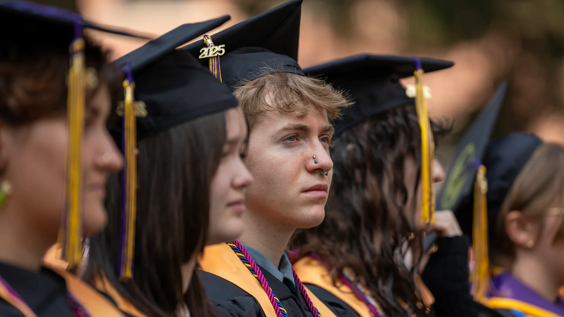 A row of Knox graduates in caps and gowns looking forward.