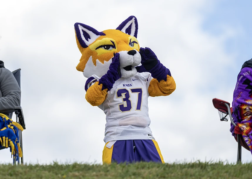 Blaze the fox, the mascot of Prairie Fire Athletics, shouts to the crowd at a football game.