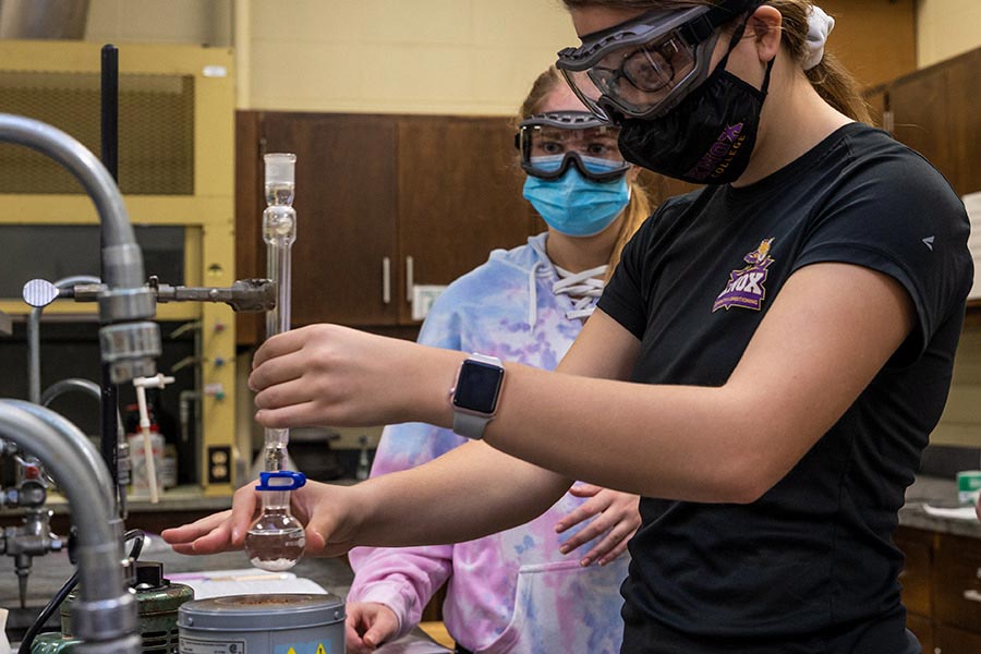 Knox chemistry students wearing goggles and masks while working in a science lab during Biofuels Week