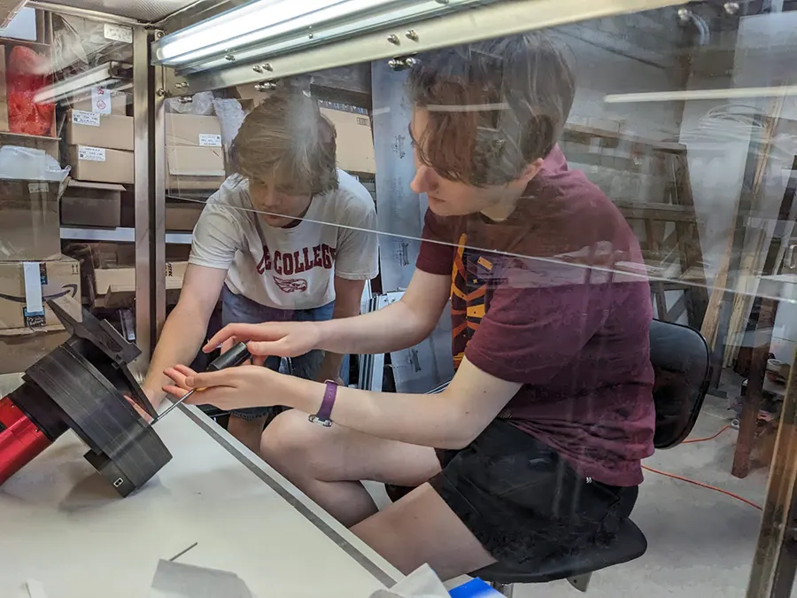 Lauren Wittry ('25) working with Walker Law (Coe '27) on the camera and filter wheel at Winer Observatory