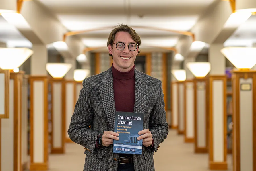 Knox College professor Thomas Bell poses with a copy of his book inside Seymour Library