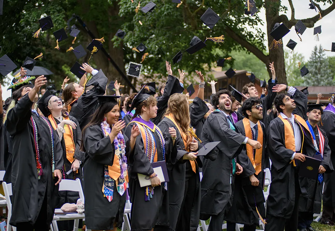 Graduates toss their caps in the air exuberantly. 