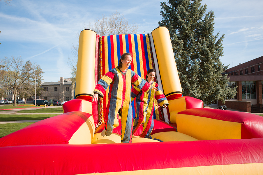 Two students climb down from a velcro wall on Flunk Day 2018.