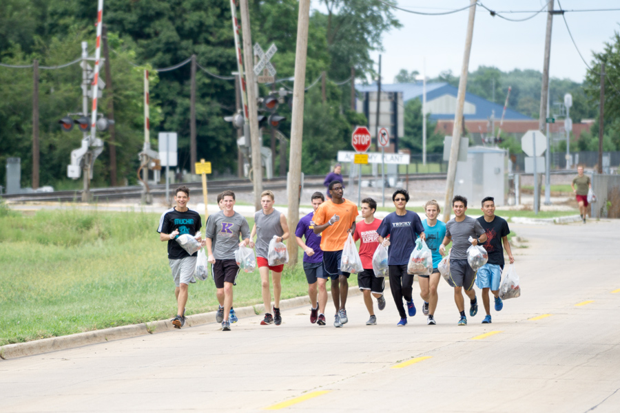 Knox College cross country athletes pick up trash in preseason practice run through Galesburg.