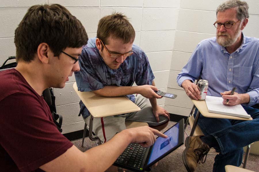 Knox College students confer with computer science professor John Dooley about a class project.