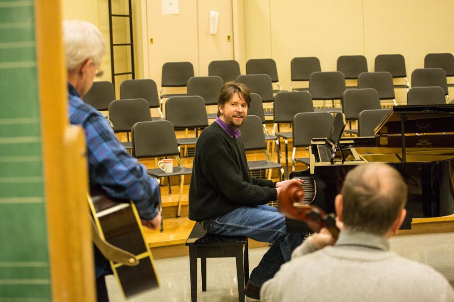 Faculty members James Thrall, guitar; Tim Kasser, piano; and David Amor, cello; play at an informal jam session during the lunch hour.