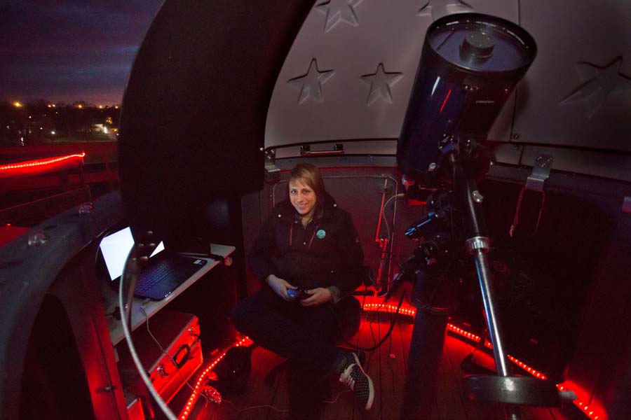 Knox College physics professor Nathalie Haurberg, with telescope, computer.