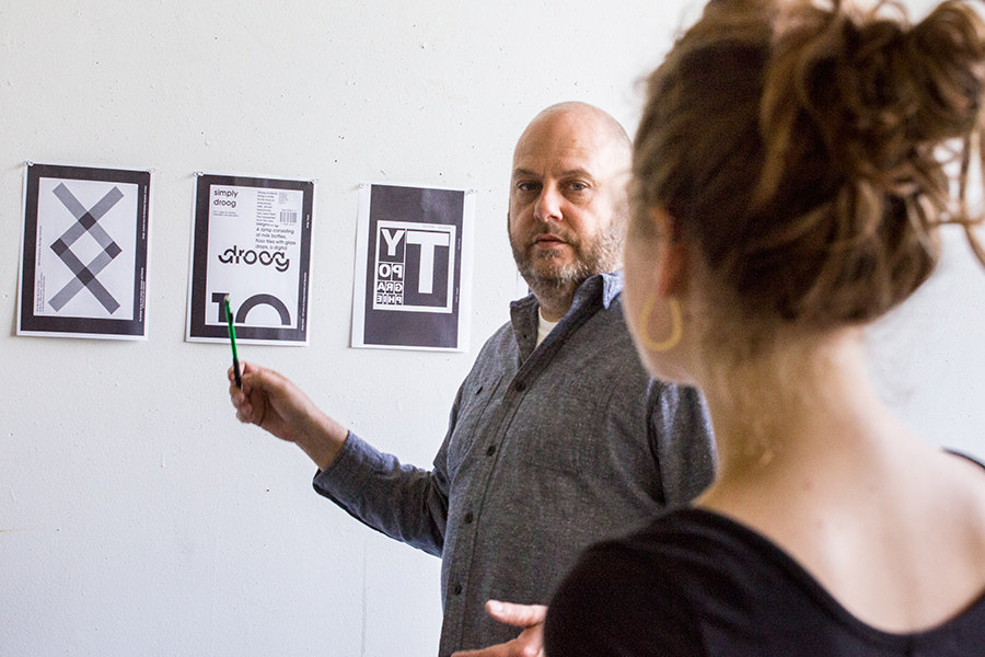 Visiting Assistant Professor of Art Tim Stedman discusses typography with a student during class.