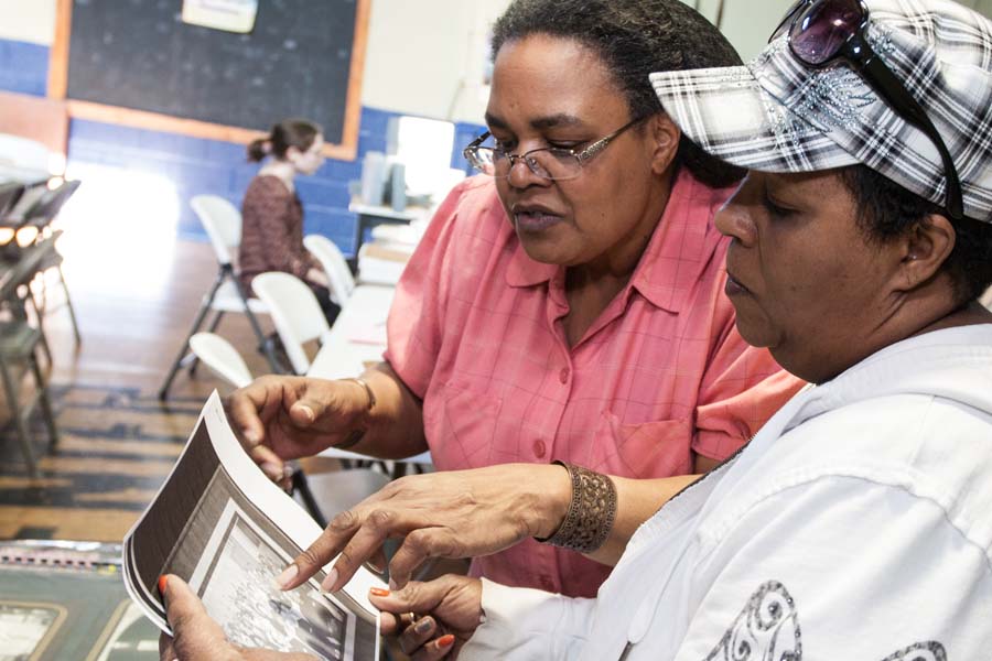 Galesburg resident Karen Ford Kelley and a friend look at family photos and other documents in a community history project at Knox College.