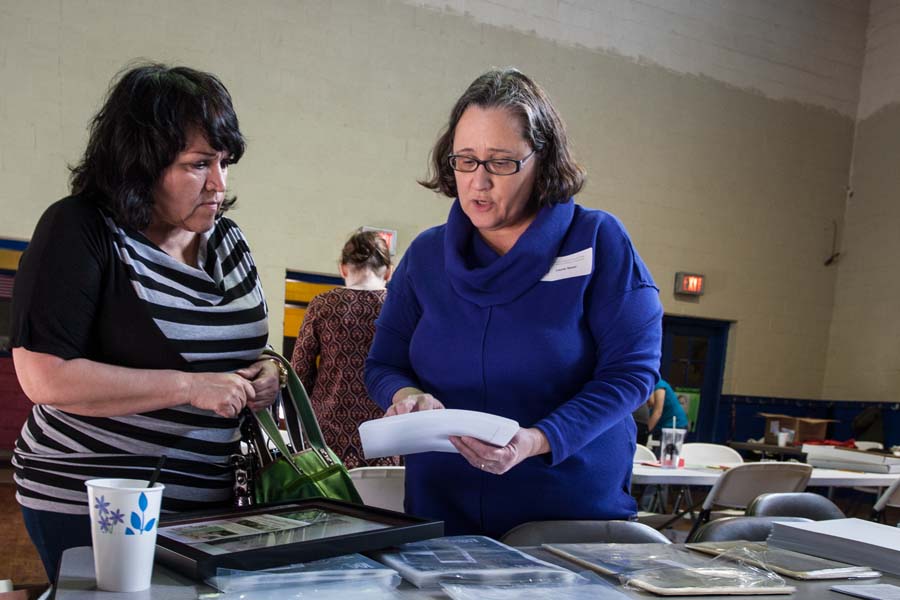 Gayla Pacheco and library staff Laurie Sauer examine family photos.