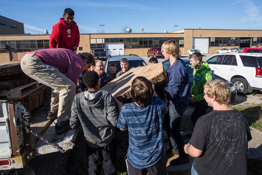 Knox College biology professor Stuart Allison delivers section of oak tree to Galesburg High School.