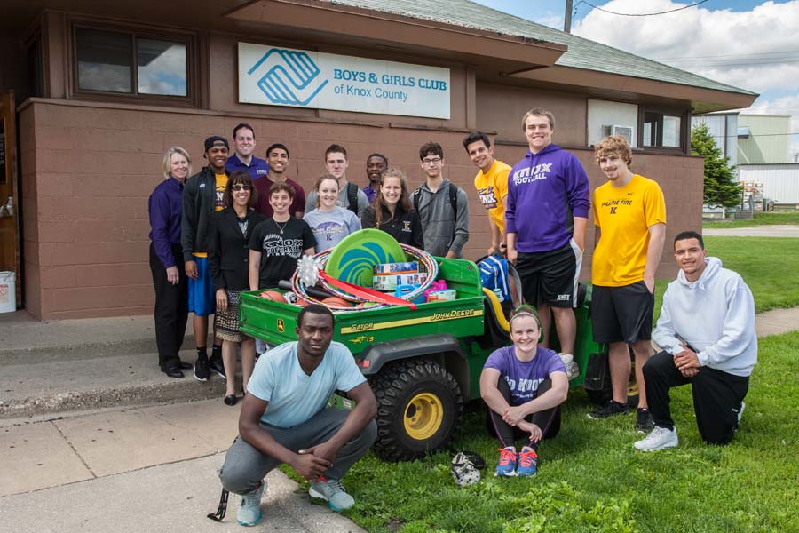 Representatives of Knox College and the Boys and Girls Club of Knox County, with a trailer filled with donated books and recreational items.