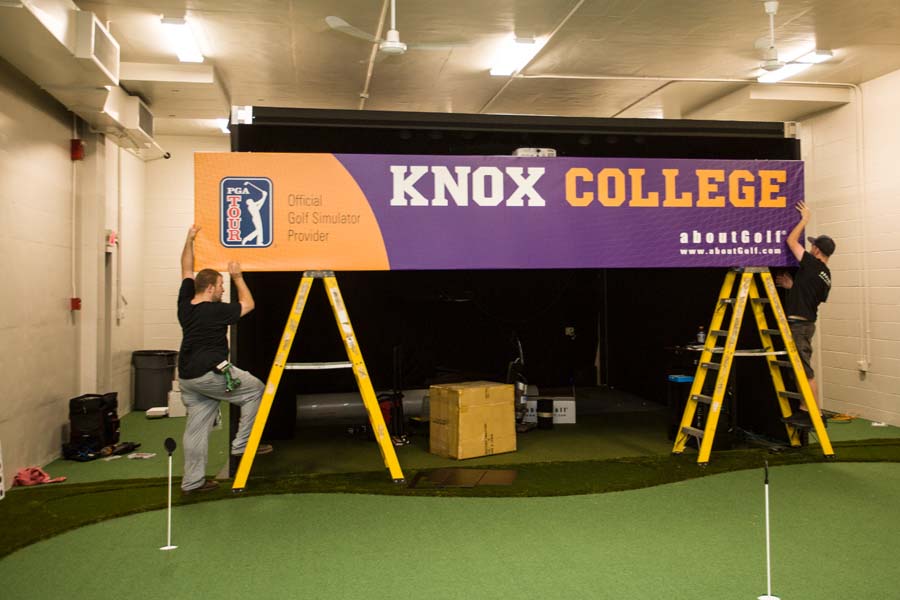 Workers building the new aboutGolf simulator at Knox College.