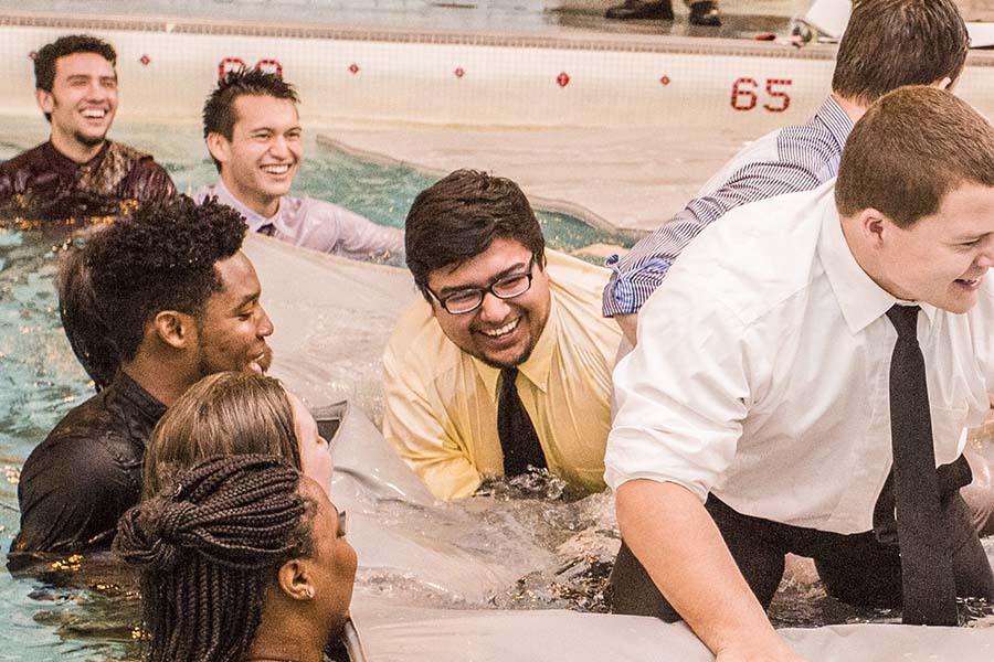 Students in psychology class Organizational Behavior with faculty Frank McAndrew, engage in team-building games in swimming pool.