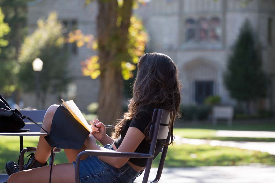 Knox College student writing in class.