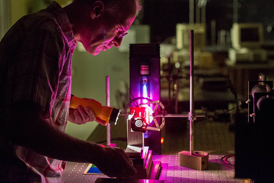 Physics professor Tom Moses adjusts a device used to analyze light -- Fabry-Perot interferometer -- that he and two students built in a physics department research lab.
