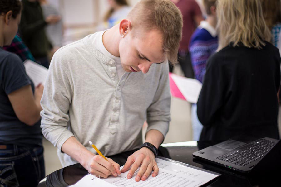 Choir student makes notes on music.