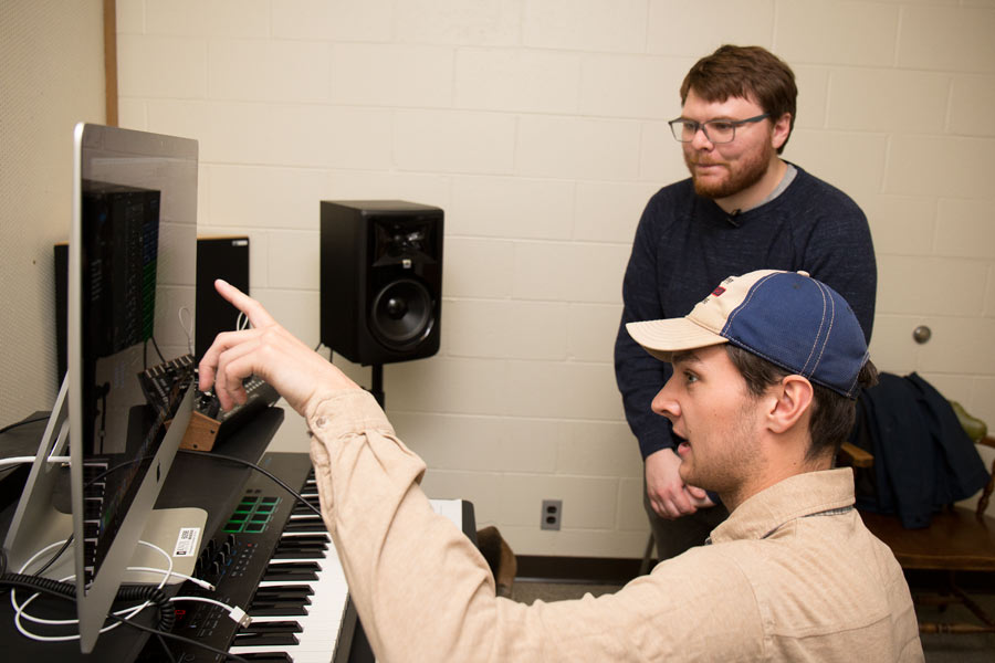 Pierce Gradone, standing, and Sam Beem in the Knox electronic music studio