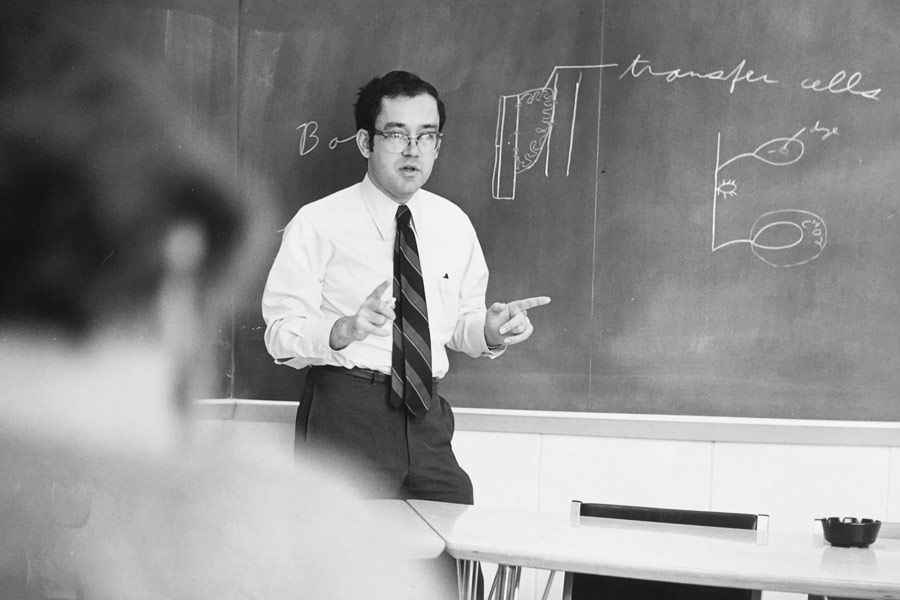 Eugene Perry stands in front of a blackboard lecturing in this archival photo.