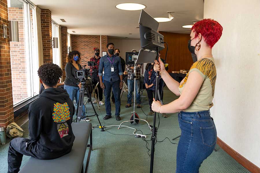 Students and filmmaker Vince Singleton set up a filmmaking shot in the lobby of the Center for Fine Arts.