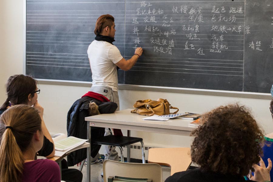 Students writing Chinese on a board.