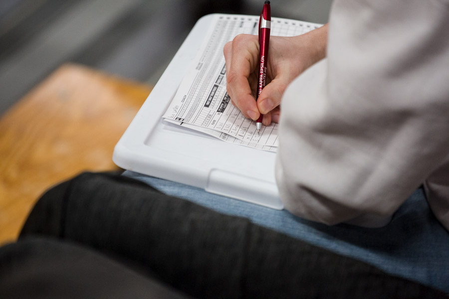 Writing sports statistics onto a sheet of paper.