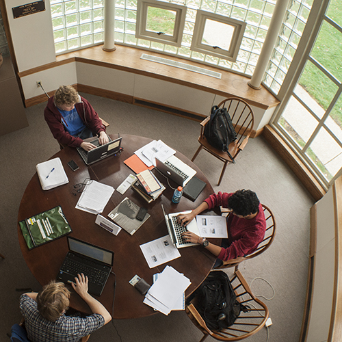 Students study around a table in the Seymour Library.