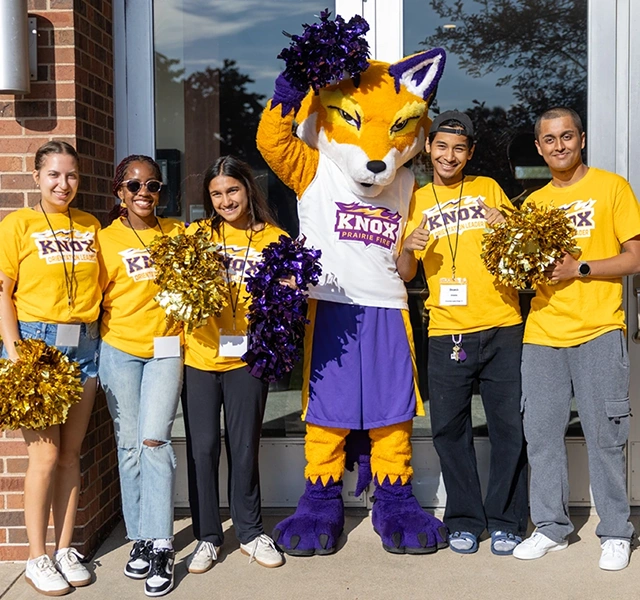 Five students pose with a fox mascot.