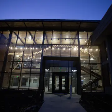 The Umbeck Science-Mathematics Center's (SMC) exterior is pictured at night, the whale skeleton illuminated on the inside.