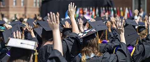 Graduates celebrating and clapping at the 2024 Knox College Commencement.
