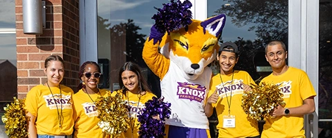 Five students pose with a fox mascot.