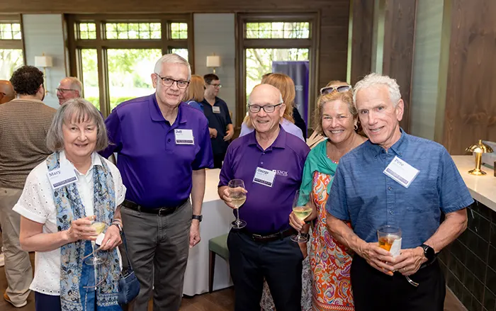 Five individuals look directly at the camera and smile.