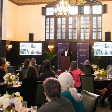 alt="A group oKnox alumni and friends listen as President C. Andrew McGadney speaks