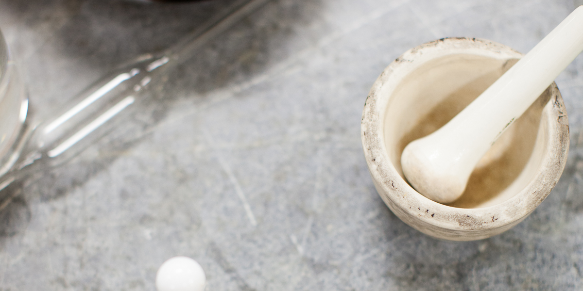 A mortar and pestle sit on a lab desk.