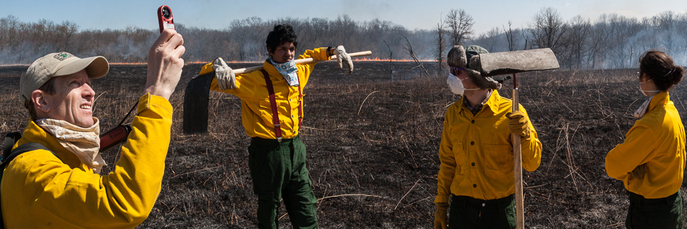 Professor Stuart Allison checks wind speed at the Green Oaks prairie burn.