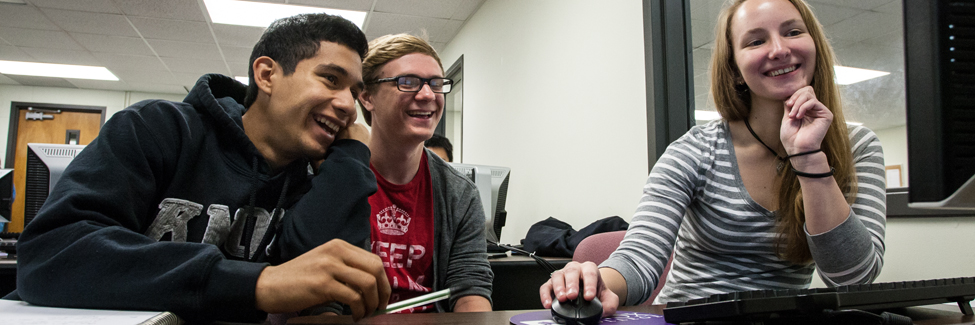 Students in a psychology class check data on a computer monitor.