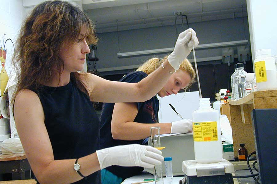 Janet Kirkley in a biochemistry lab with a student.