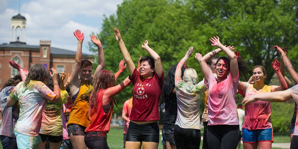 Students dance on the south lawn of Old Main to celebrate the Indian Holi festival.