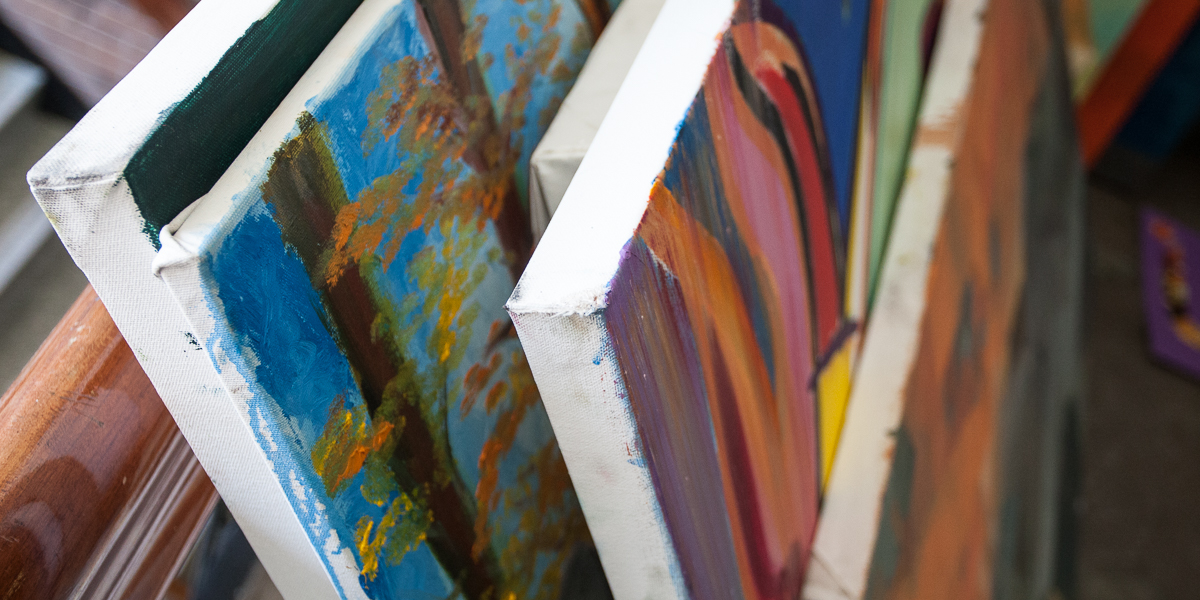 Student paintings stacked in preparation for the Al Young Student Art Show. 