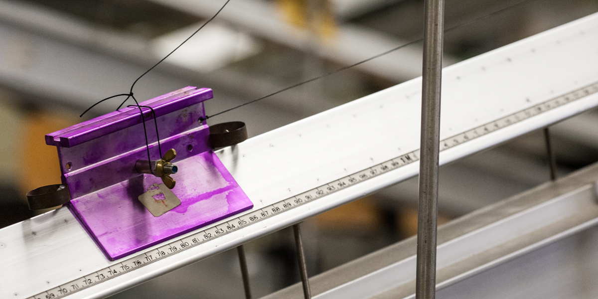 Purple slider on an air track in a physics lab.