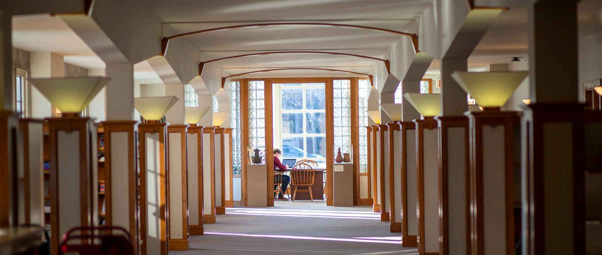 A student studies inside the glass atrium at the Seymour Library.